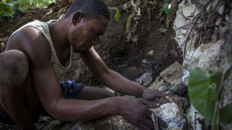 Ein Kleinbauer in Haiti untersucht einen erodierten Erdrutsch
