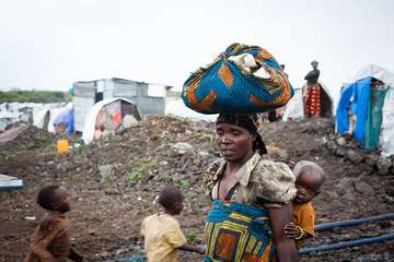 Eine Mutter mit ihrem Kind auf dem Rücken, geflohen aus dem Kongo.