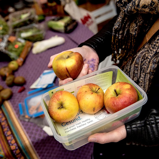 Lebensmittelverschwendung stoppen. Bild: Eine Frischhaltebox mit drei Äpfeln.