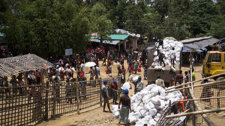 Im Camp Hakimpara in Bangladesch: Mitarbeiter der lokalen Hilfsorganisation FIVDB laden Säcke mit Holzkohle und Reisschalenbriketts von einem Truck (August 2018).
