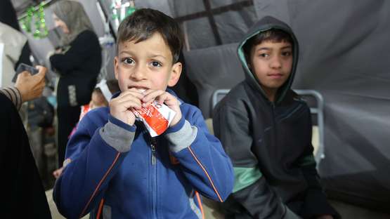 Kinder in Gaza bekommen und essen Spezialnahrung im Rahmen einer Nothilfeaktion