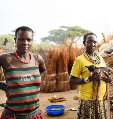 Eine Frau hält eine Ziege auf dem Arm in Moroto, Uganda.