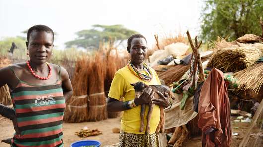 Eine Frau hält eine Ziege auf dem Arm in Moroto, Uganda.