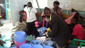 Ein Welthungerhilfe-Mitarbeiter verteilt Eimer und weitere Dinge zur Wasseraufbereitung