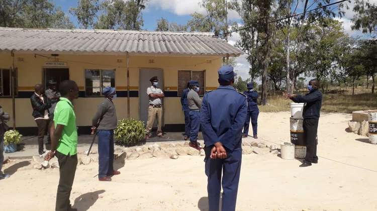 EHO, eine Partnerorganisation der Welthungerhilfe, demonstriert auf der Polizeistation Donga in Simbabwe, wie man sich die Hände wäscht.