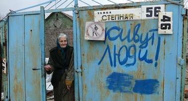 Eine ältere Dame steht in der Tür und ist verwundet; das Bild steht für Spenden für die Ukraine, 2022.