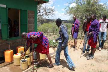 Menschen am Wasserkiosk in Nentaraja, Kenia.