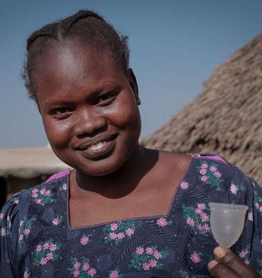Eine junge Frau zeigt eine Menstruationstasse, Bentiu, Unity State, Südsudan Januar 2022. 