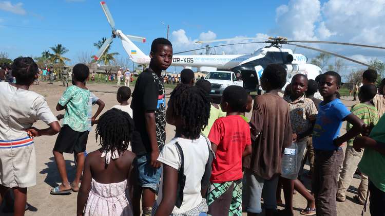 Kinder und Jugendliche stehen erwartungsvoll vor einem großen Helikopter.
