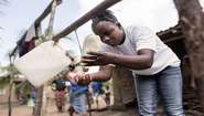Frauen waschen sich ihre Hände am Tipi-Tap, einer behelfsmäßigen Handwaschanlage in Sierra Leone.