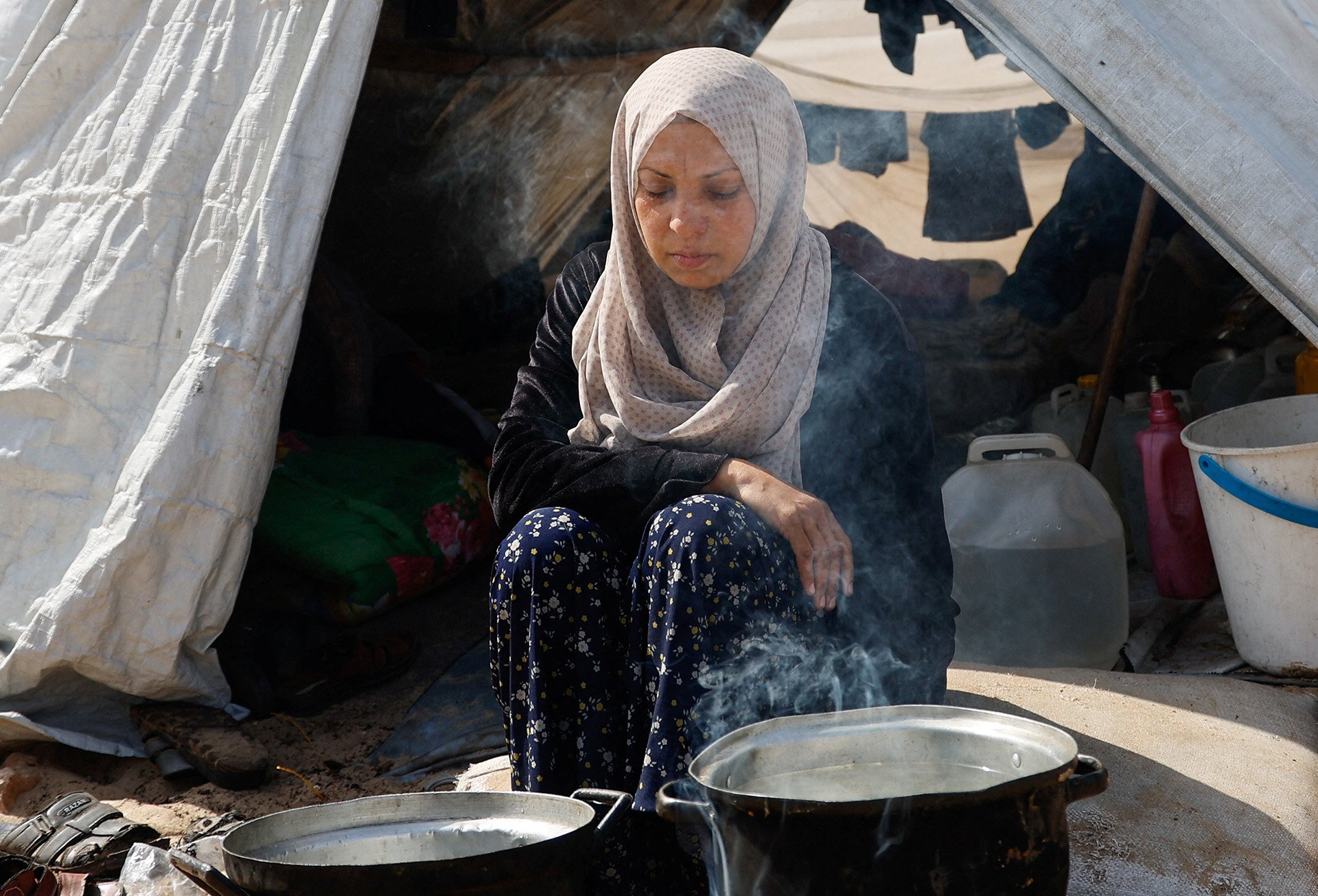 Eine geflüchtete Frau kocht in Gaza, 2024.