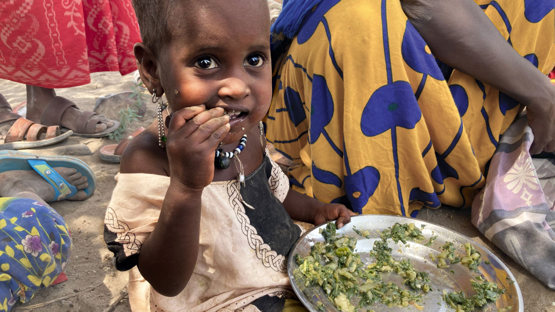 Dürre in Äthiopien. Ein Kleinkind isst Gemüse von einem Metallteller. 