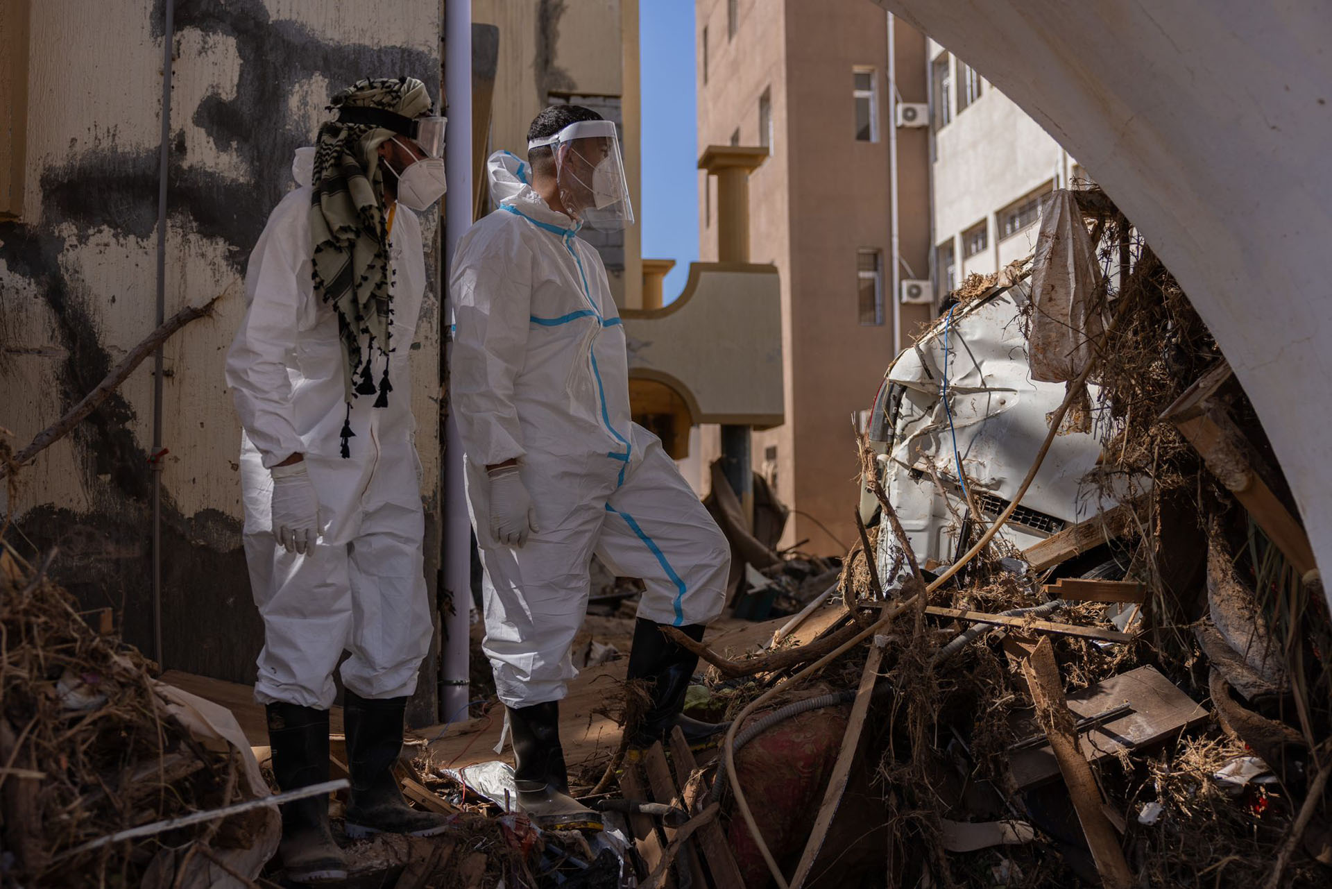 Hilfskräfte in Schutzanzügen und mit Masken inspizieren die Folgen der Überschwemmungen in Derna, Libyen. Krankheiten könnten sich verstärkt ausbreiten.